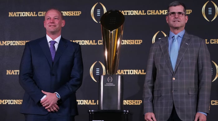 Washington’s Kalen DeBoer, Michigan’s Jim Harbaugh pose in front of 2024 College Football Playoff trophy.